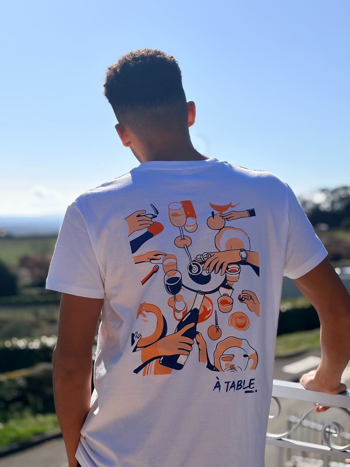T-shirt À TABLE ! illustré, porté face aux vignes du Beaujolais