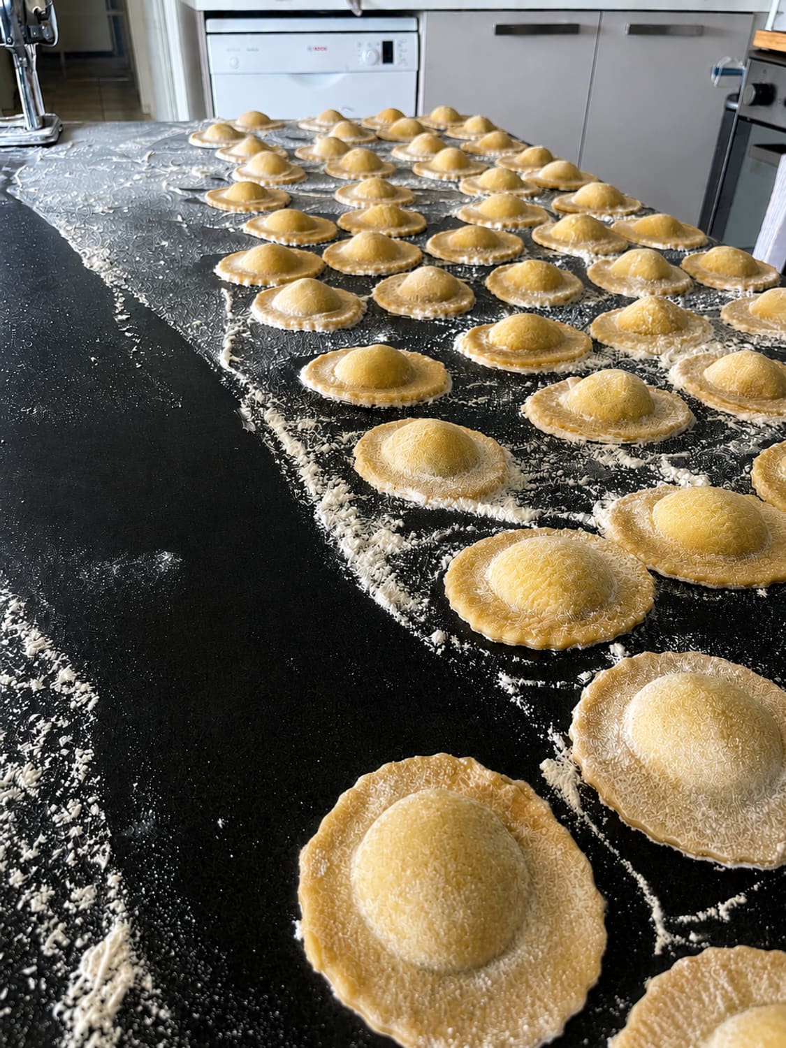 Raviolis frais maison en cours de dressage sur le plan fariné