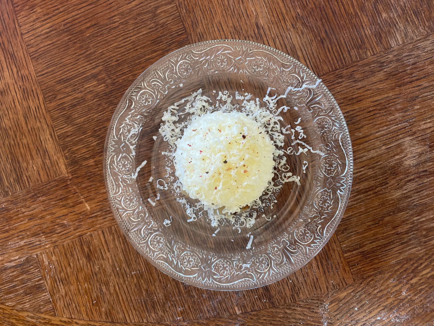 Plat gratiné, parmesan fraîchement râpé sur assiette en verre ciselé